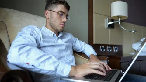Handsome entrepreneur use notebook for work sitting in armchair at home inter Stock Photos