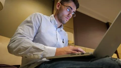 Handsome entrepreneur use notebook for work sitting in armchair at home inter Stock Photos
