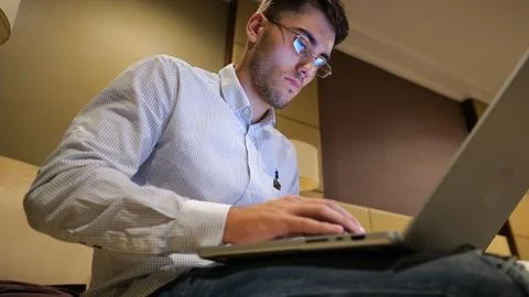 Handsome entrepreneur use notebook for work sitting in armchair at home inter Stock Photos