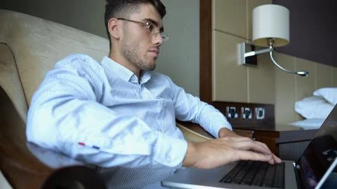 Handsome entrepreneur use notebook for work sitting in armchair at home inter Stock Photos