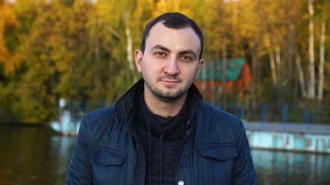 Handsome european man is looking to camera over autumn background Stock Footage 141815665