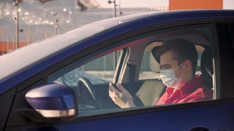 Handsome European man wearing protecrive mask disinfects hands with an Stock Footage 144321953