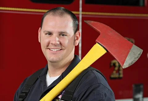 Handsome fireman with ax close up Stock Photos