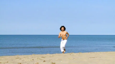 Handsome fit man jogging on beach without tshirt in summer Stock Footage 37111434