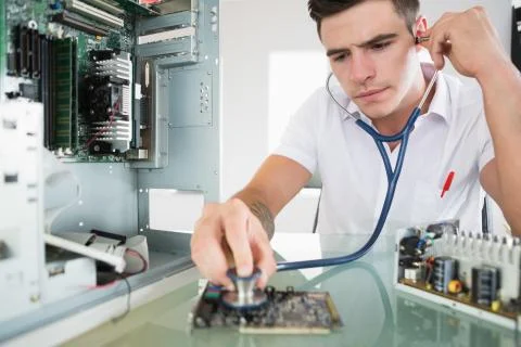 Handsome focused computer engineer holding stethoscope Stock Photos