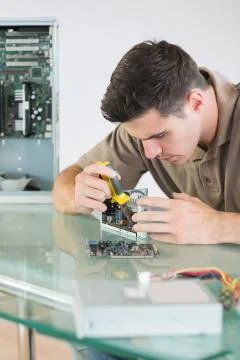 Handsome focused computer engineer repairing hardware with pliers Stock Photos