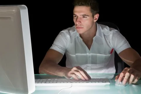 Handsome focused computer engineer working at night Stock Photos