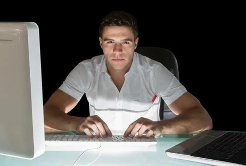 Handsome frowning computer engineer working at night Stock Photos