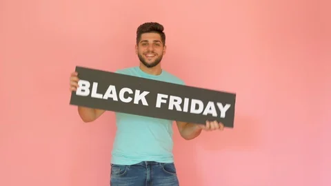 Handsome funny smiling guy with black friday sign dancing isolated over pink Stock Footage 116454025