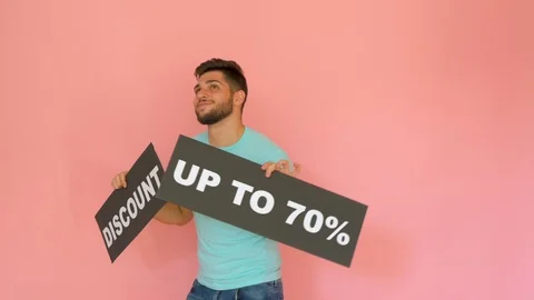 Handsome funny smiling guy with discount up to 70% sign dancing isolated over Stock Footage 116454993