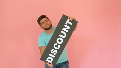 Handsome funny smiling guy with discount sign dancing isolated over pink Stock Footage 116455192