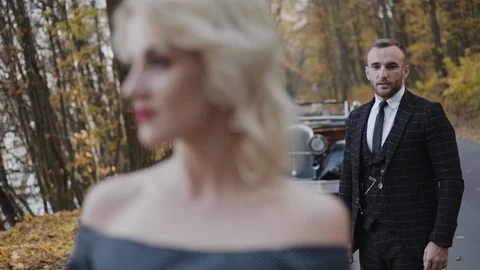 Handsome gentleman admires the seductive posing lady and they look aside Video stock 124731576