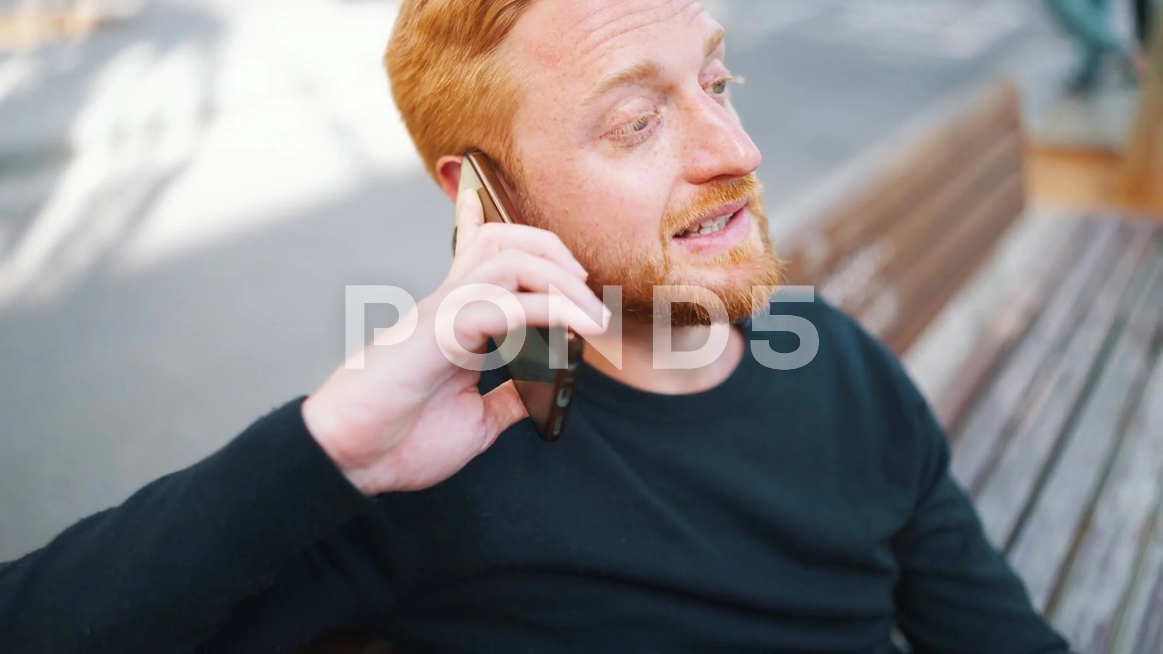 Handsome ginger man talking by smartphone