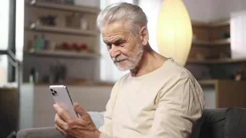 Handsome gray haired man hold smartphone browsing scrolling app watching social Stock Footage 253513748