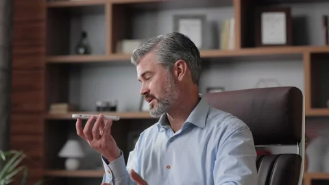 Handsome gray-haired man recording voice message on smartphone. Businessman 스톡 동영상 196926145