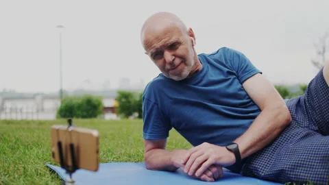 Handsome Gray-Haired Old Man Watching Digital Video Content on Smartphone Screen Stock Footage 148467729