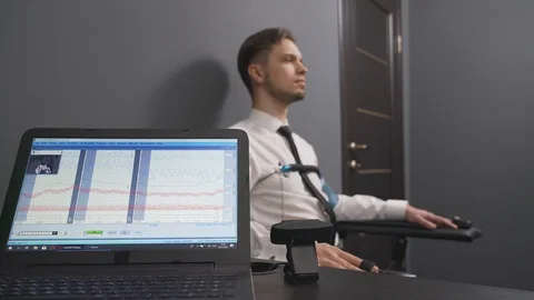 Handsome guy answering questions during polygraph test Stock Footage 122627929