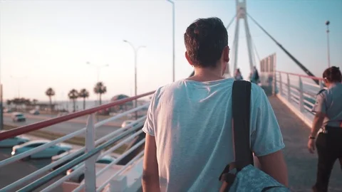 Handsome guy with backpack walking and drinking bottle water. Stock Footage 112880332