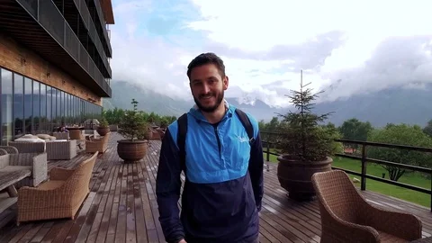 Handsome guy with a beard walking on the terrace and smiling Video stock 87352032