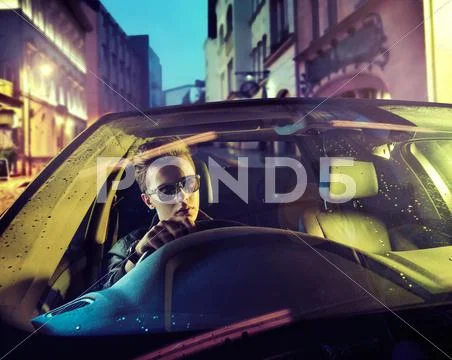 Handsome guy behind the car wheel Stock Photos