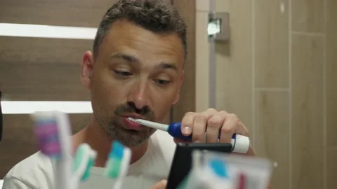 Handsome guy brushes teeth Stock Footage 157972285