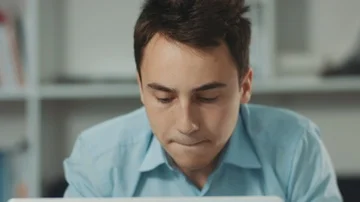 Handsome guy in business clothes playing computer game during dinner in modern Stock Footage 85631357