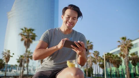 Handsome guy cute laughing watching video content on smartphone eating healthy Stock Footage 109419194