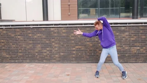 Handsome guy dancing hip hop, modern dance free style on the city street. Stock Footage 139758241