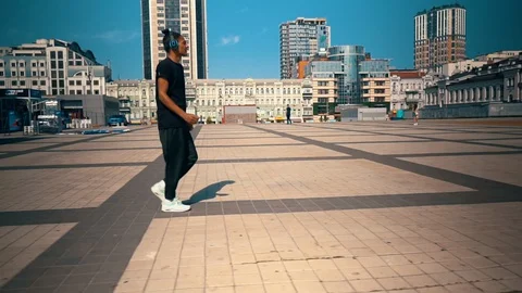 Handsome guy dancing walks on the square Stock Footage 127857012