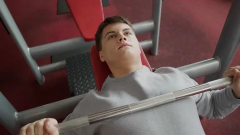 Handsome guy doing exercises with a barbell in the gym. Stock Footage 154894263