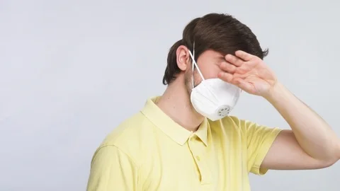 Handsome guy in face protector measure body temperature with arm on his head Stock Footage 127111926