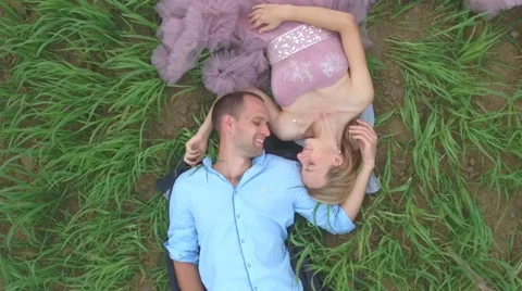 Handsome guy with girlfriend lying on the field and dreaming. Stock Footage 64033535