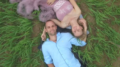 Handsome guy with girlfriend lying on the field and dreaming. Stock Footage 64033783