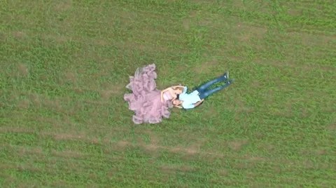 Handsome guy with girlfriend lying on the field and dreaming. Stock Footage 64034390