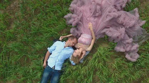 Handsome guy with girlfriend lying on the field and dreaming. Stock Footage 64035131