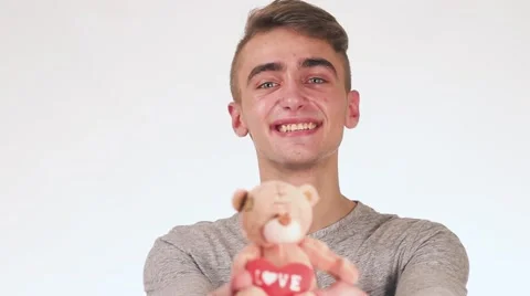 Handsome Guy Gives a Gift to His Girlfriend. In the hands of a guy toy teddy Stock-Footage 58627461