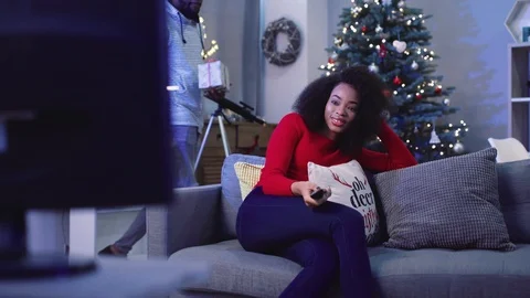 Handsome guy giving Christmas present to girlfriend on background of fascinated Stock Footage 85611431