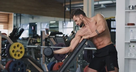 Handsome guy in a gym class bodybuilding concept lifting up the dumbbell to Stock Footage 114760769