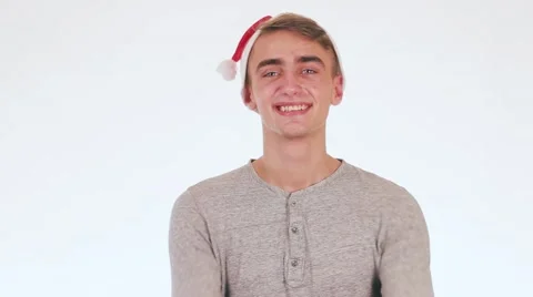 Handsome guy in the hat of Santa Claus gives a gift and smiles. Stock-Footage 58627499