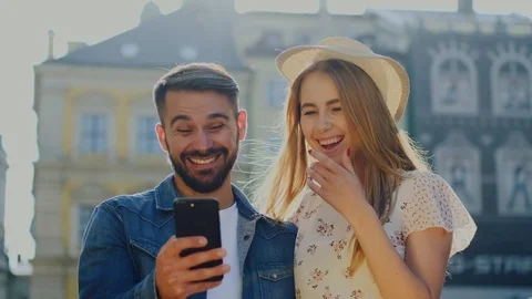 Handsome guy in jeans jacket and beautiful girl in stylish hat laughing from fun Stock Footage 112352031