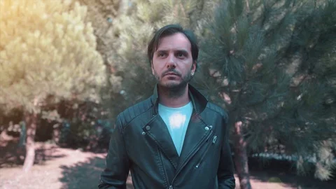 Handsome guy with leather jacket is walking outdoor. Charismatic young bearded Stock Footage 119654270