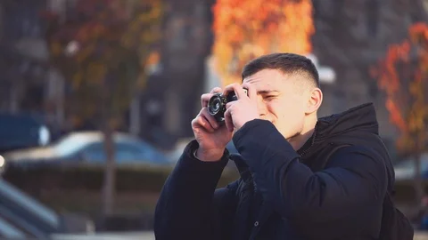 Handsome guy is looking around and taking a photo. He is happy and smiling. Copy Stock Footage 123224664