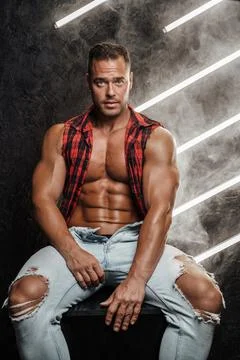 Handsome guy with muscular build dressed in trendy ripped clothes Stock Photos