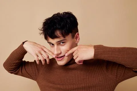 Handsome guy posing in brown sweater self confidence fashion isolated background Stock Photos