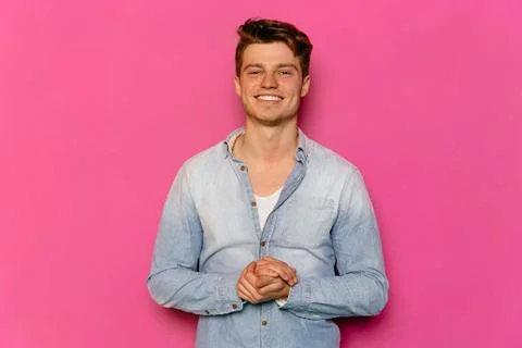 Handsome guy posing at camera on pink background. Stock-Fotos