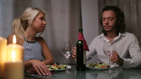 A handsome guy is pouring wine and looking at a girl Stock Footage 104914840