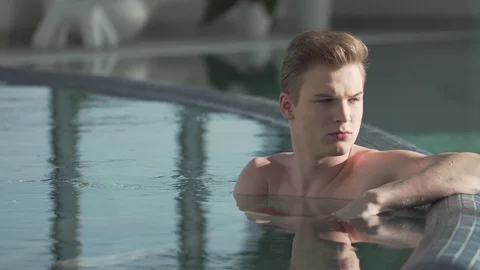 Handsome guy resting in the pool Stock Footage 127181193