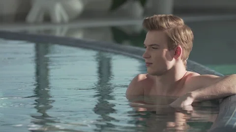 Handsome guy resting in the pool Stock Footage 127181194