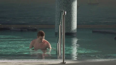 Handsome guy resting in the pool Stock Footage 127181286