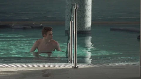 Handsome guy resting in the pool Stock Footage 127181304